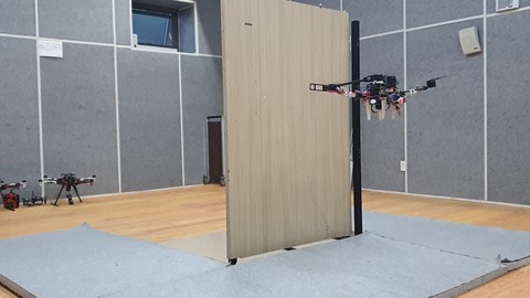 서울대학교 공과대학 김현진 교수 연구팀이 개발한 비행형 머니퓰레이터가 로봇 팔을 이용해 문을 열고 있다