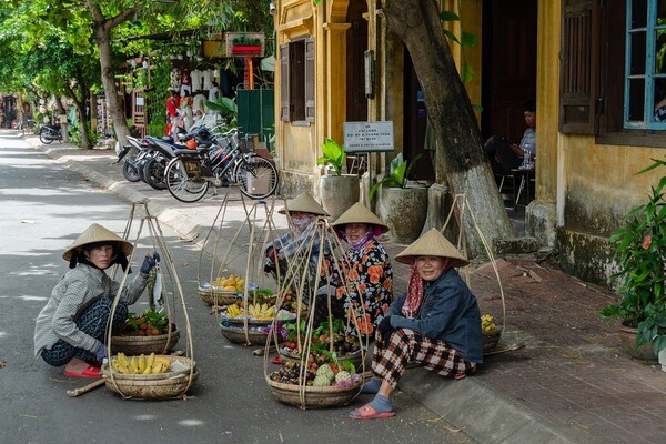 베트남 호이안 거리에서 과일을 파는 사람들