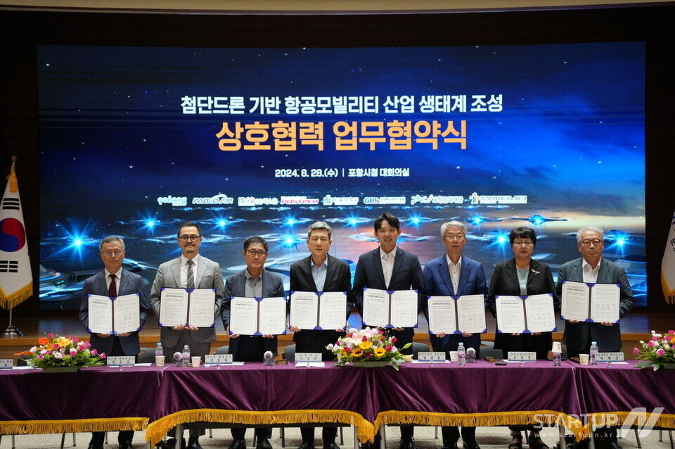 김영준 파블로항공 대표이사(오른쪽 네 번째)가 포항시청에서 포항시 및 기관들과 함께 첨단드론 기반 메이저 토토 사이트 육성을 위한 상호협력 업무협약을 체결하고 기념사진을 촬영하고 있다.