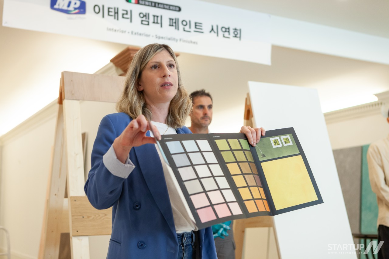 カラーリブックメーカープロ 野球ピッチョ・エムピーのマスタブックメーカープロ 野球アプリケーターがデコラティブ・ペイントを説明している様子