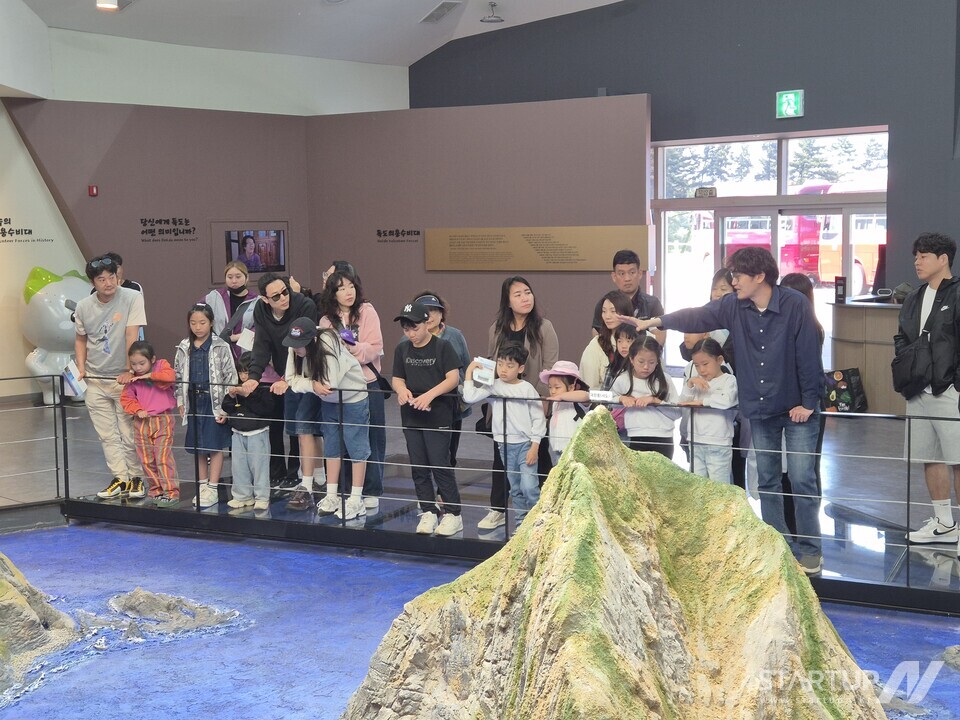 온라인카지노의의용수비대기념관에서 온라인카지노 조형물을 관람하고 교육받는 아이들